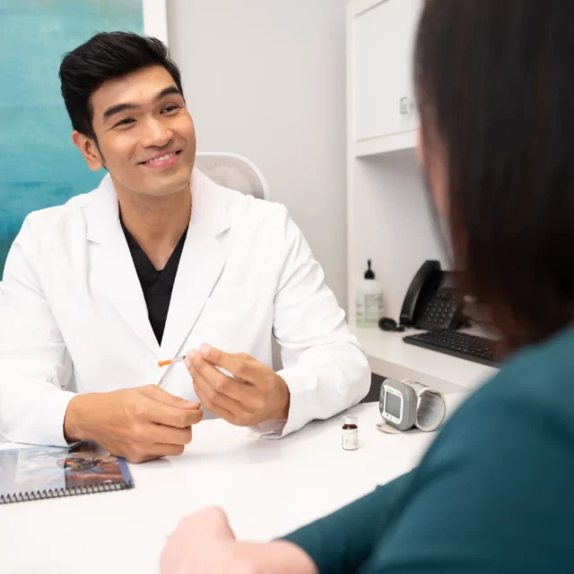 Options medical provider speaking with a patient in a clinic exam room.